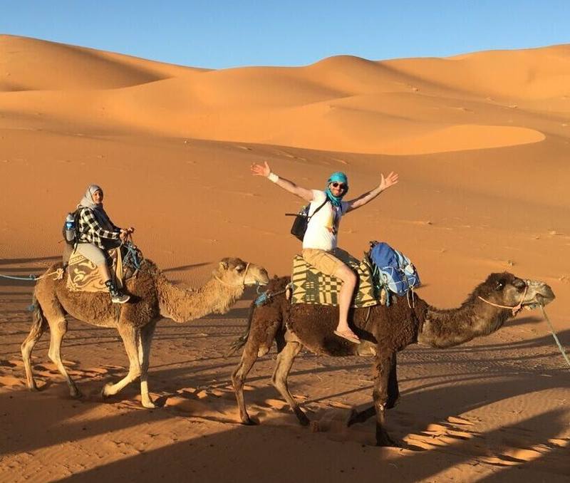 Aaron riding a camel while travelling abroad